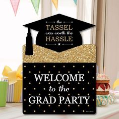 welcome to the grad party sign in black and gold with a graduation cap on top