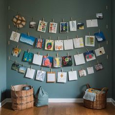 there are many pictures hanging on the clothesline and some baskets in front of them