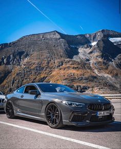 two cars parked in front of a mountain