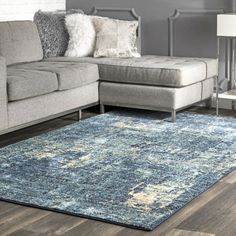 a living room with a gray couch and blue rug