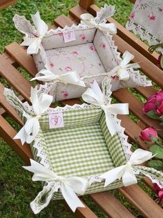 two small boxes with bows on them sitting in the grass next to pink roses and flowers