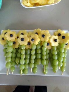 grapes and sunflowers are arranged on skewers to look like they were made from grapes