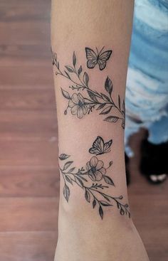 a woman's arm with butterflies and flowers tattooed on the left side of her leg