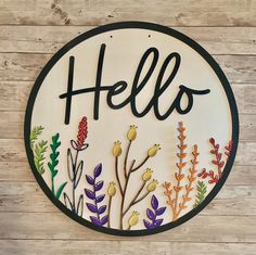 a sign with the word hello painted on it's side and flowers in the middle