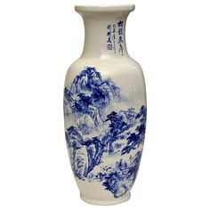 a blue and white vase with mountains on it's side, in front of a white background