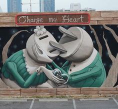 a large mural painted on the side of a building with two people holding each other