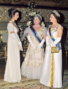 three women dressed in white and gold standing next to each other on a carpeted floor