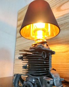 an old motorcycle engine with a lamp on it's head sitting on a table