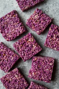 purple rice krispy treats are arranged on a table