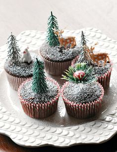 cupcakes decorated with frosting and trees on a plate