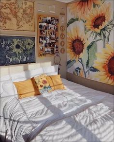 a bedroom with sunflowers painted on the wall and pictures hanging above the bed