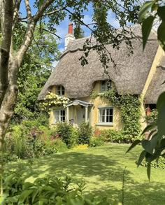 a house with a thatched roof surrounded by greenery