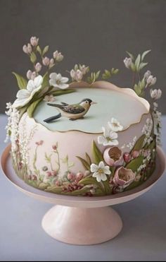 a decorated cake with flowers and birds on it