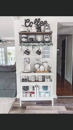 a kitchen with white cabinets and shelves filled with coffee cups, tea kettles and mugs