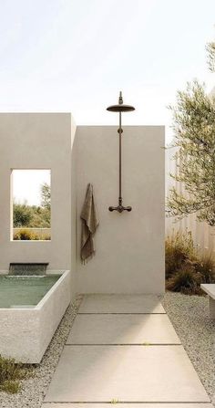 an outdoor bathtub and shower in the middle of a courtyard with stone flooring