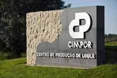 the sign for cimpor is displayed in front of some green grass and trees