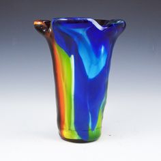 a multicolored glass vase sitting on top of a table