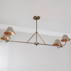 a chandelier hanging from the ceiling in a room with white walls and light fixtures