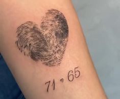 a close up of a person's arm with a fingerprint tattoo on it