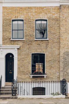 a brick building with black iron fence and windows