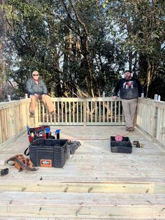 two men standing on a deck with tools