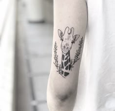 a giraffe tattoo on the left arm