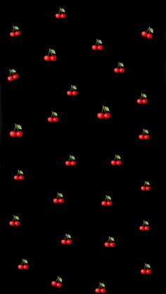 a black background with red cherries and green leaves