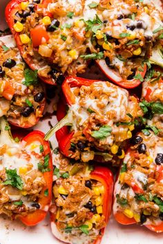 stuffed bell peppers topped with cheese, black beans and cilantro sauce on a white plate