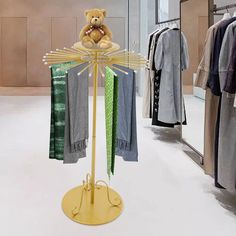 a teddy bear sitting on top of a clothes rack