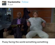 two men sitting on a couch in front of each other, one reading a magazine