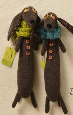 two stuffed dogs with scarves and tags on their ears are sitting next to each other