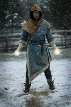 a man dressed in medieval clothing standing in the snow