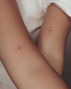 two small stars on the back of someone's arm, both with their arms crossed