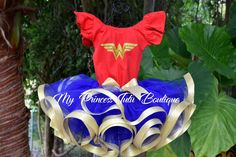 a red shirt and blue skirt with gold trims on it, sitting on top of a tree