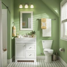 a bathroom with green walls and white fixtures