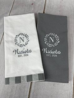 two personalized towels sitting on top of a wooden table