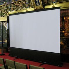 a large screen in the middle of a room with rows of chairs on either side