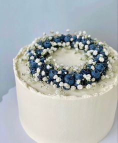 a white cake topped with blue and white flowers