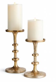 two white candles sitting on top of each other