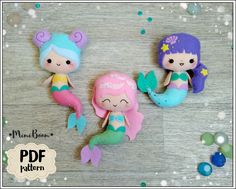 three little mermaid dolls sitting next to each other on a wooden table with bubbles around them