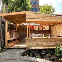 a small wooden shelter sitting next to a tree