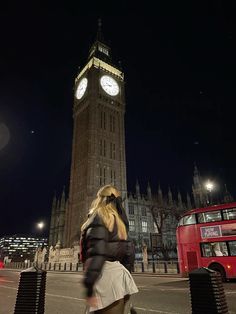 a woman walking down the street in front of big ben