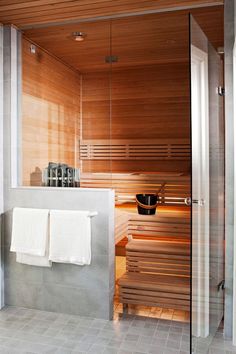 a bathroom with a sauna in the middle and towels hanging on the wall next to it