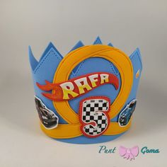 a blue and yellow crown with cars printed on the front, sitting on a white surface