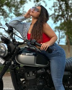 a woman sitting on the back of a motorcycle