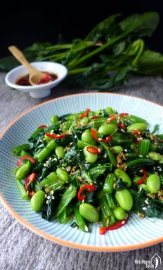 a white plate topped with green vegetables and sauce