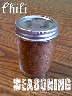 a mason jar filled with chili seasoning sitting on top of a wooden table