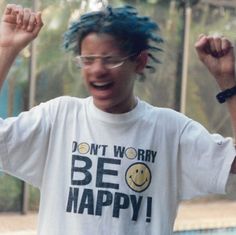 a man with dreadlocks wearing a t - shirt that says don't worry be happy