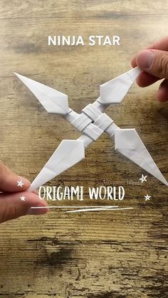 two hands holding origami birds on top of a wooden table with the words ninja star