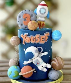 a birthday cake with an outer space theme on it's top and the words youself written in large letters